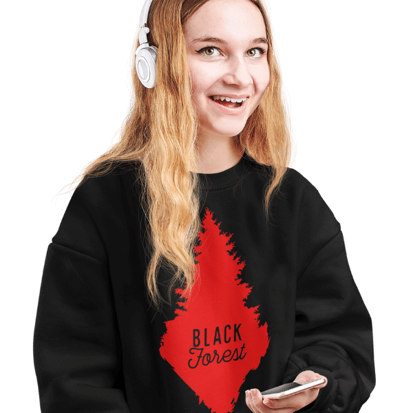 blonde frau im studio mit kopfhoerern und schwarzem pulli mit rote schwarzwald tanne design