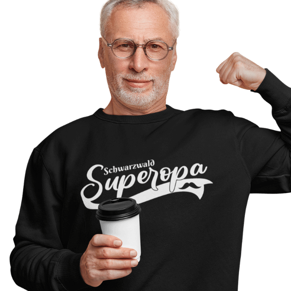 grauhaariger mann mit brille und kaffee mit schwarzem sweatshirt mit aufdruck schwarzwald super opa