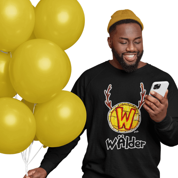 mann mit luftballoons und handy im studio mit schwarzem tshirt mit waelder hochschwarzwald design