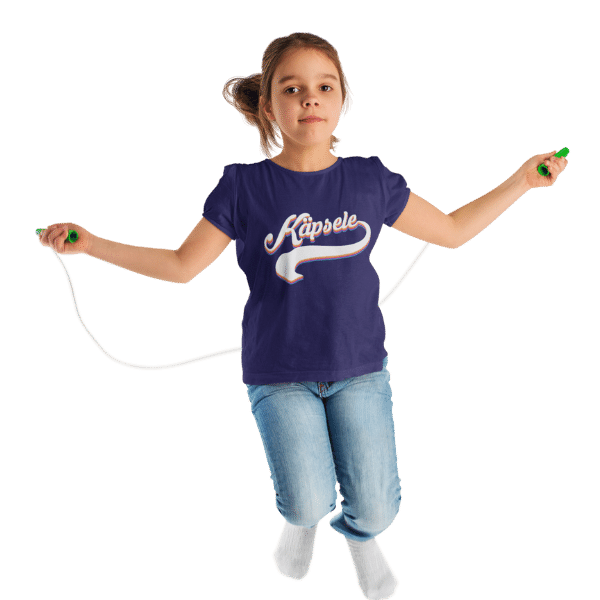 maedchen springend im studio mit blauem t-shirt mit kaepsele design