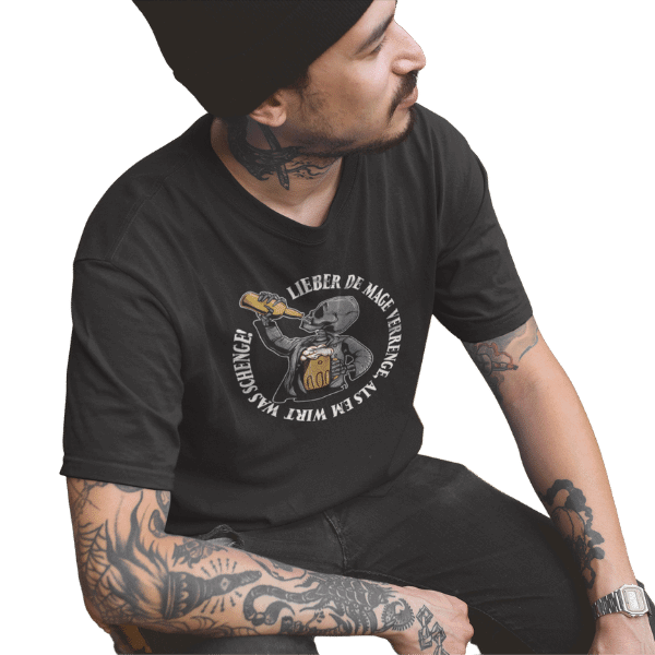 mann im studio mit muetze und schwarzem tshirt mit aufdruck lieber de mage verrenge als em wirt was schenge