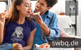 frau mit blauem t-shirt mit motiv schwarzwald braut mit bollenhut sitzend mit ihrem freund auf dem sofa