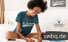 frau sitzend auf einem bett mit gruenem tshirt mit furtwangen motiv