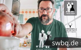mann in der kueche mit gruenem shirt mit motiv junggesellenabschied im schwarzwald