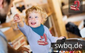 kleiner blonder junge mit hellblauem langarm t-shirt mit 2. geburtstag schwarzwald design