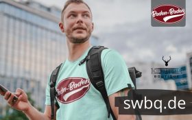 mann mit rucksack und hellblauem tshirt mit logo baden-baden