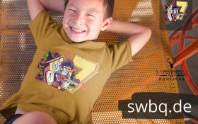 junge auf dem boden liegend mit hellbraunem t-shirt mit aufdruck 7. geburtstag schwarzwald