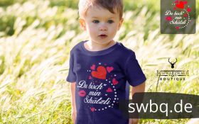 kleines kind auf der wiese mit blauem t-shirt mit schwarzwald schaetzli aufdruck