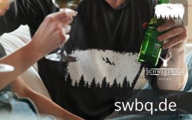 mann trinkt mit freunden mit schwarzem tshirt mit balck forest wildness design
