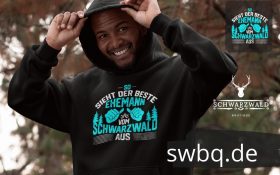 gluecklicher mann mit schwarzem hoodie mit design bester ehemann aus dem schwarzwald