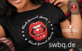 glueckliche frau mit schwarzem tshirt mit black forest cherry design