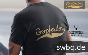 rueckenansicht eines mannes im studio mit einem schwarzen tshirt mit dem design gopferdori alemannisch