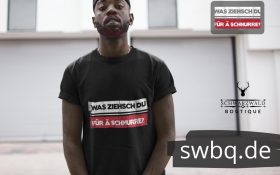 mann mit bart und schwarzem t-shirt mit motiv was ziehsch du fuer ae schnurre