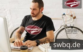 mann mit bart am schreibtisch mit schwarzem t-shirt mit design emmendingen