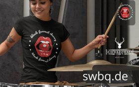 frau mit schlagzeug und schwarzem tshirt mit black forest cherry bildmotiv