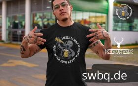 mann mit brille und schwarzem t-shirt mit motiv lieber de mage verrenge als em wirt was schenge