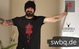 mann mit muetze, bart und schwarzem shirt mit schwarzwaelder kuckucksuhr rot design