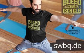 mann beim yoga mit schwarzem t-shirt mit motiv badisch bleed gschwaetzt