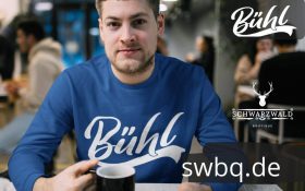 mann mit kaffee und blauem t-shirt mit buehl aufdruck
