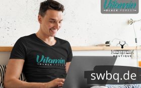 mann mit computer und schwarzem t-shirt mit black forest vitamin design