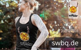 frau in yoga pose im freien mit einem schwarzen tank top mit logo waelder hochschwarzwald